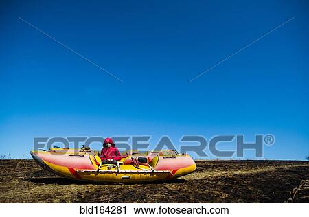 Stock Image - Caucasian boy sitting on catamaran in rural field. Fotosearch