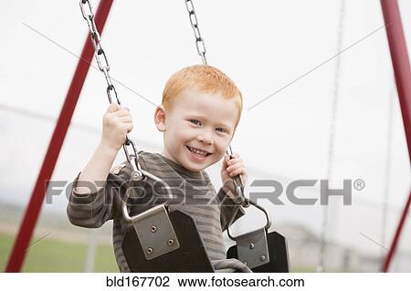 Caucasian boy sitting on playground swing View Large Photo Image Stock Image - Caucasian boy sitting on playground swing. Fotosearch