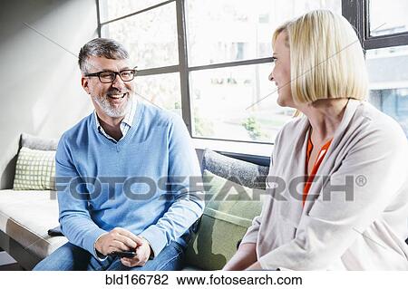 Stock Image - Caucasian business people talking in office lobby. Fotosearch