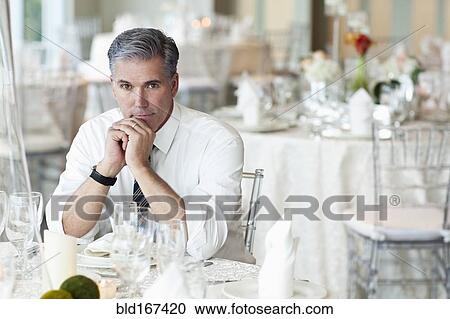 Caucasian businessman sitting in empty dining room View Large Photo Image Stock Image - Caucasian businessman sitting in empty dining room. Fotosearch
