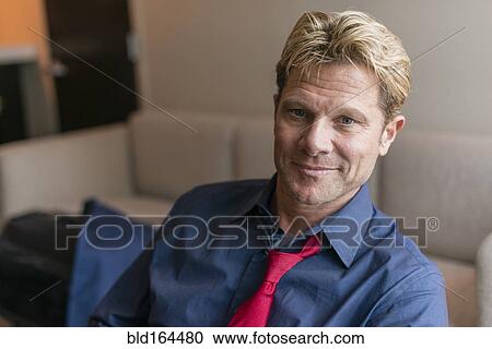 Caucasian businessman sitting in office lobby View Large Photo Image Stock Image - Caucasian businessman sitting in office lobby. Fotosearch