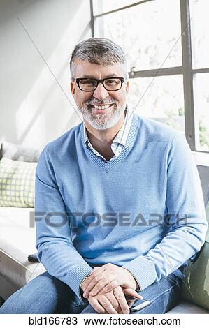 Stock Image - Caucasian businessman smiling in office lobby. Fotosearch