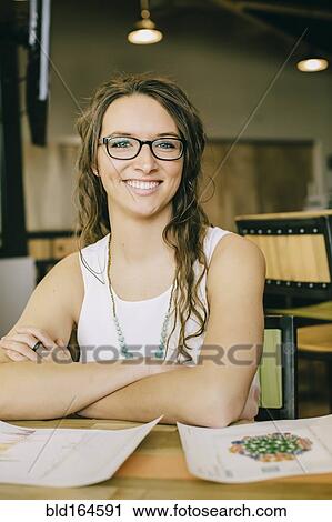 Stock Image - Caucasian businesswoman smiling in cafe. Fotosearch