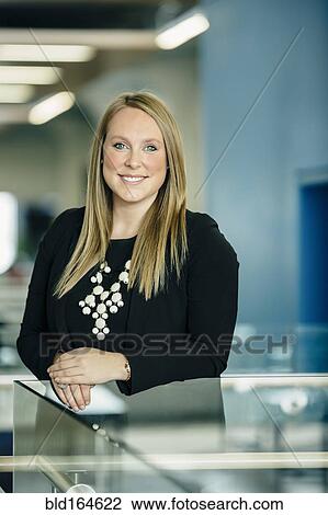 Stock Image - Caucasian businesswoman smiling in office. Fotosearch