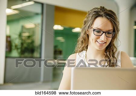 Stock Photo - Caucasian businesswoman using laptop in cafe. Fotosearch