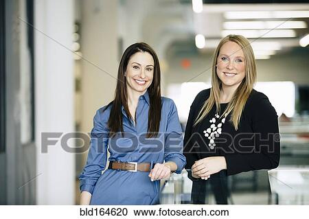 Caucasian businesswomen smiling in office View Large Photo Image Stock Image - Caucasian businesswomen smiling in office. Fotosearch