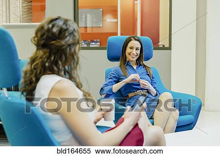 Caucasian businesswomen talking in office lobby View Large Photo Image Stock Photography - Caucasian businesswomen talking in office lobby. Fotosearch