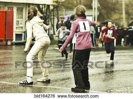 Stock Photograph - Caucasian children preparing for race on street. Fotosearch