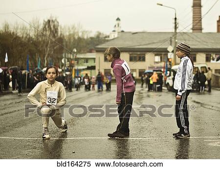 Stock Photography - Caucasian children preparing for race on street. Fotosearch