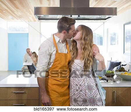 Caucasian couple kissing in kitchen View Large Photo Image Stock Photo - Caucasian couple kissing in kitchen. Fotosearch