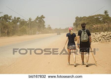 Caucasian couple walking on dirt road in remote field View Large Photo Image Stock Image - Caucasian couple walking on dirt road in remote field. Fotosearch