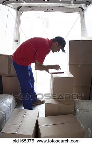 Caucasian delivery man using digital tablet in van View Large Photo Image Stock Photograph - Caucasian delivery man using digital tablet in van. Fotosearch