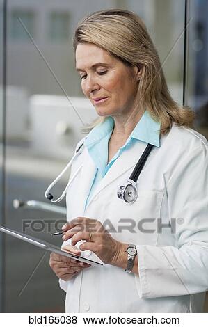 Stock Photo - Caucasian doctor using digital tablet in hospital. Fotosearch