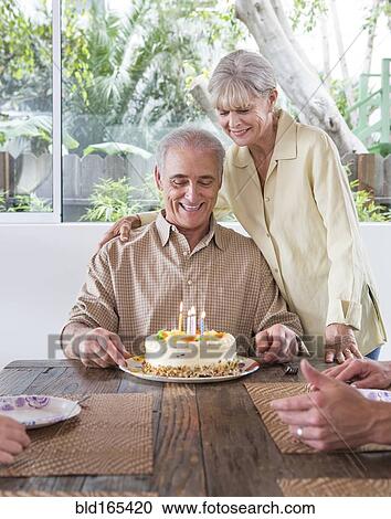 Stock Image - Caucasian family celebrating birthday at table. Fotosearch