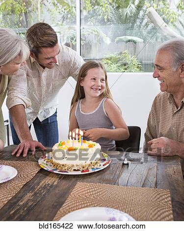 Stock Image - Caucasian family celebrating birthday at table. Fotosearch