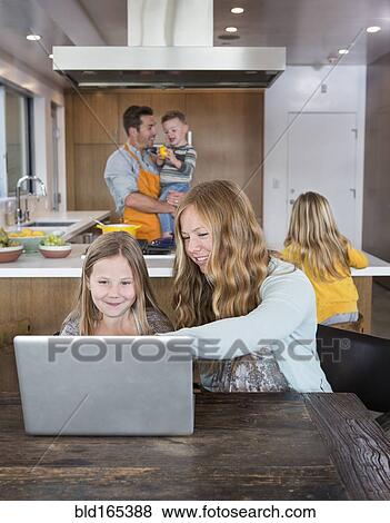 Caucasian family relaxing in kitchen View Large Photo Image Stock Photo - Caucasian family relaxing in kitchen. Fotosearch