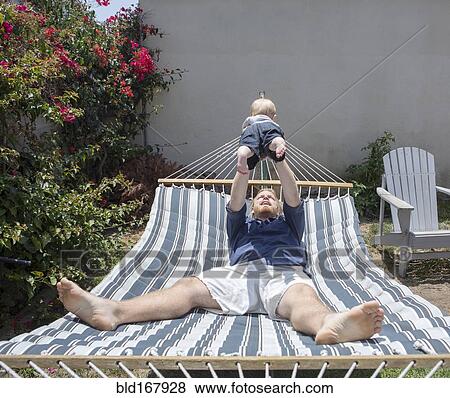 Caucasian father and son playing on hammock View Large Photo Image Stock Photo - Caucasian father and son playing on hammock. Fotosearch