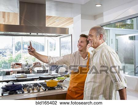 Caucasian father and son taking selfie in kitchen View Large Photo Image Stock Image - Caucasian father and son taking selfie in kitchen. Fotosearch