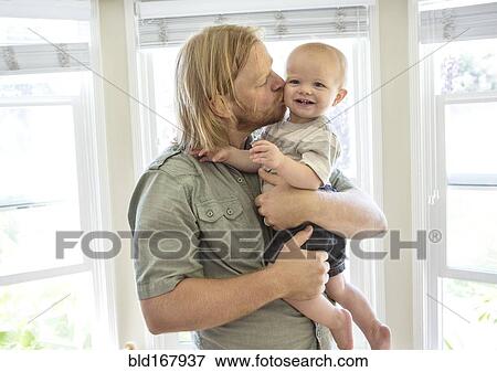 Caucasian father kissing son indoors View Large Photo Image Stock Photo - Caucasian father kissing son indoors. Fotosearch