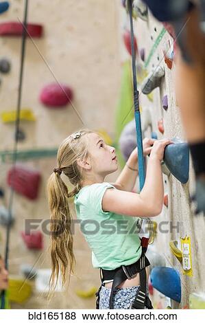 Caucasian girl climbing rock wall indoors View Large Photo Image Stock Photo - Caucasian girl climbing rock wall indoors. Fotosearch