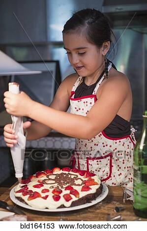 Caucasian girl decorating cake in kitchen View Large Photo Image Stock Image - Caucasian girl decorating cake in kitchen. Fotosearch