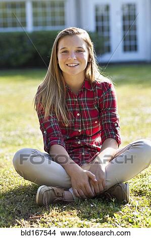 Picture - Caucasian girl sitting in backyard. Fotosearch