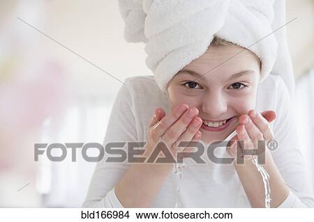 Caucasian girl washing face in bathroom View Large Photo Image Picture - Caucasian girl washing face in bathroom. Fotosearch
