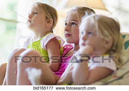 Caucasian girls watching television in armchair View Large Photo Image Stock Photo - Caucasian girls watching television in armchair. Fotosearch