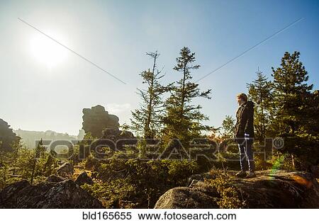Stock Photography - Caucasian hiker admiring view from remote hilltop. Fotosearch