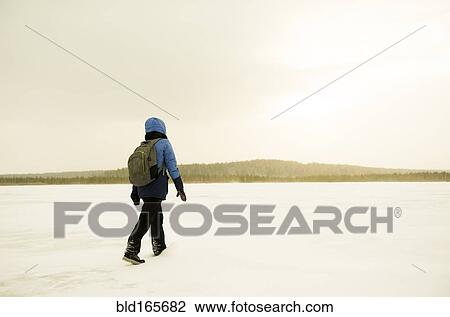 Caucasian hiker walking in snowy remote field View Large Photo Image Stock Image - Caucasian hiker walking in snowy remote field. Fotosearch