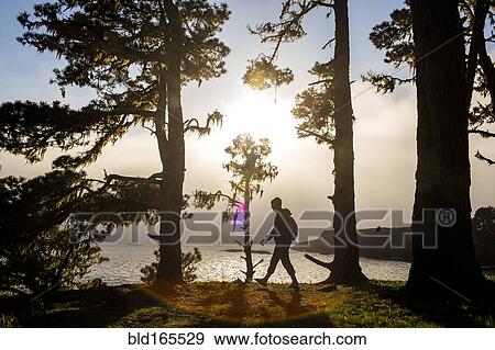 Stock Photo - Caucasian hiker walking near ocean. Fotosearch