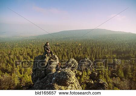 Stock Photo - Caucasian hikers admiring view from remote rock formation. Fotosearch
