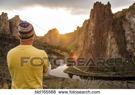 Stock Photo - Caucasian man admiring scenic desert landscape, Smith Rock State Park, Oregon, United States. Fotosearch