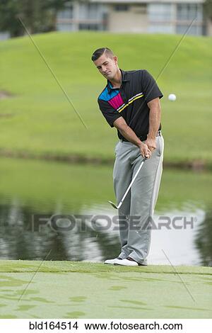 Caucasian man chipping on golf course View Large Photo Image Picture - Caucasian man chipping on golf course. Fotosearch