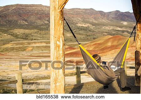 Caucasian man drinking coffee in hammock, Painted Hills, Oregon, United States View Large Photo Image Stock Photo - Caucasian man drinking coffee in hammock, Painted Hills, Oregon, United States. Fotosearch