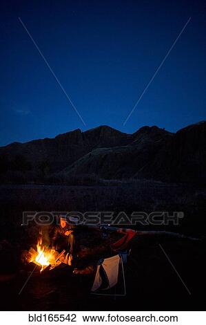 Caucasian man sitting near campfire in remote landscape View Large Photo Image Stock Image - Caucasian man sitting near campfire in remote landscape. Fotosearch