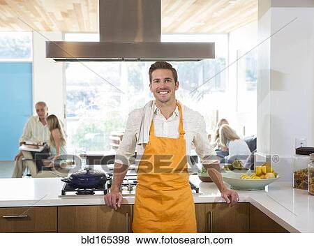 Stock Photo - Caucasian man smiling in kitchen. Fotosearch