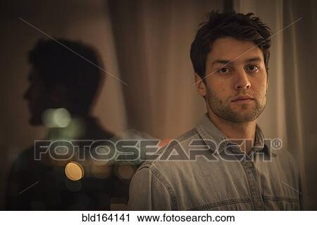 Caucasian man standing near window at night View Large Photo Image Stock Image - Caucasian man standing near window at night. Fotosearch