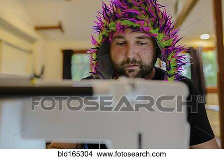 Caucasian man wearing fuzzy hat using sewing machine View Large Photo Image Picture - Caucasian man wearing fuzzy hat using sewing machine. Fotosearch