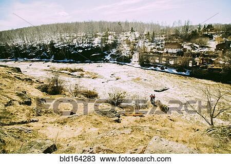 Stock Image - Caucasian men standing near remote river. Fotosearch