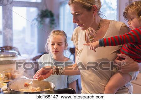 Caucasian mother and children cooking in kitchen View Large Photo Image Stock Photo - Caucasian mother and children cooking in kitchen. Fotosearch
