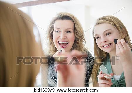 Caucasian mother and daughter applying makeup in mirror View Large Photo Image Stock Photo - Caucasian mother and daughter applying makeup in mirror. Fotosearch