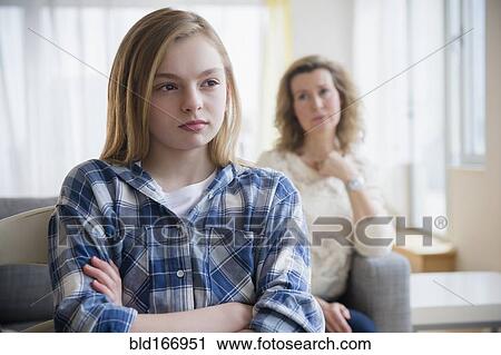 Stock Image - Caucasian mother and daughter arguing in living room. Fotosearch