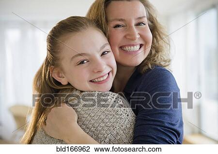 Caucasian mother and daughter hugging in living room View Large Photo Image Stock Image - Caucasian mother and daughter hugging in living room. Fotosearch
