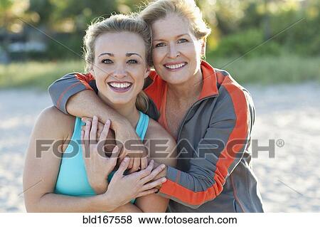 Stock Photo - Caucasian mother and daughter hugging outdoors. Fotosearch