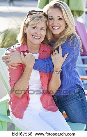 Stock Photograph - Caucasian mother and daughter hugging outdoors. Fotosearch