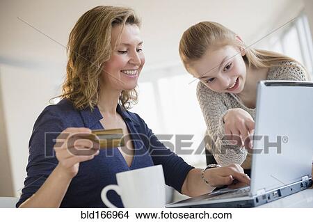 Picture - Caucasian mother and daughter shopping online. Fotosearch