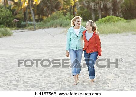 Caucasian mother and daughter walking on beach View Large Photo Image Stock Photograph - Caucasian mother and daughter walking on beach. Fotosearch