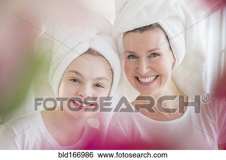 Stock Photograph - Caucasian mother and daughter wearing towels in hair. Fotosearch
