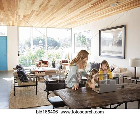 Caucasian mother and daughters using laptop in living room View Large Photo Image Stock Photograph - Caucasian mother and daughters using laptop in living room. Fotosearch